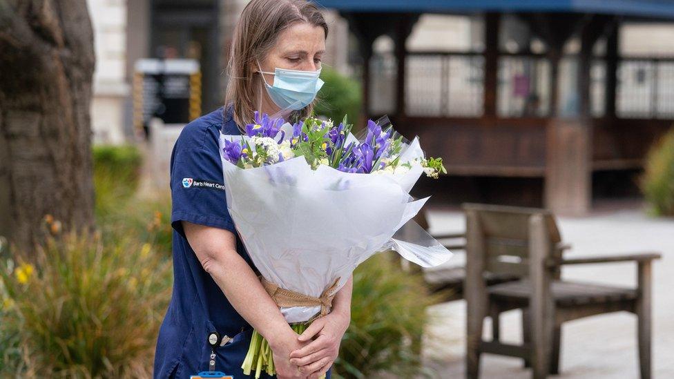 Staff at St Bartholomew's Hospital, London, receive flowers from Queen Elizabeth II on the anniversary of the first national lockdown