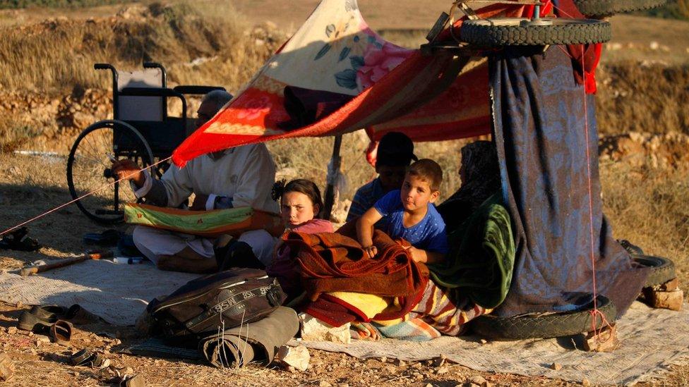 Displaced Syrians from the Deraa province wait in a makeshift camp near the town of Nassib to cross the Jordanian border (1 July 2018)