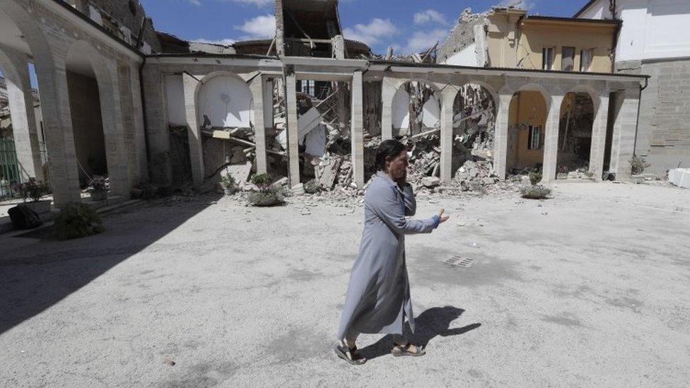 A nun in the courtyard of a damaged convent in Amatrice