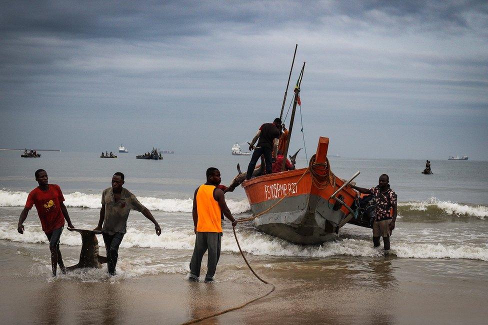 Fishermen standing by their boat