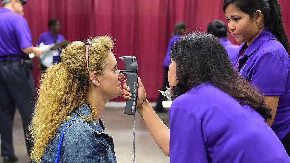 A women has her eyes checked at a mobile health clinic for people without medical insurance