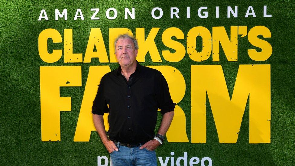 Clarkson in front of a poster for his show