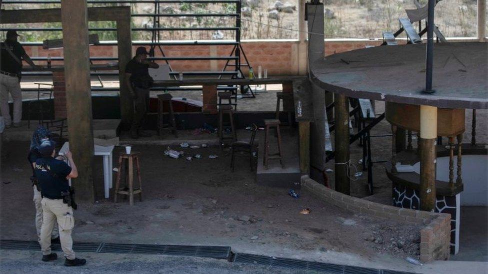 Agents of the Michoacán Attorney General's office stand at a clandestine cockfighting ring following the killing of at least 20 people on Sunday night during an attack, authorities said, in Zinapecuaro, Mexico March 28, 2022