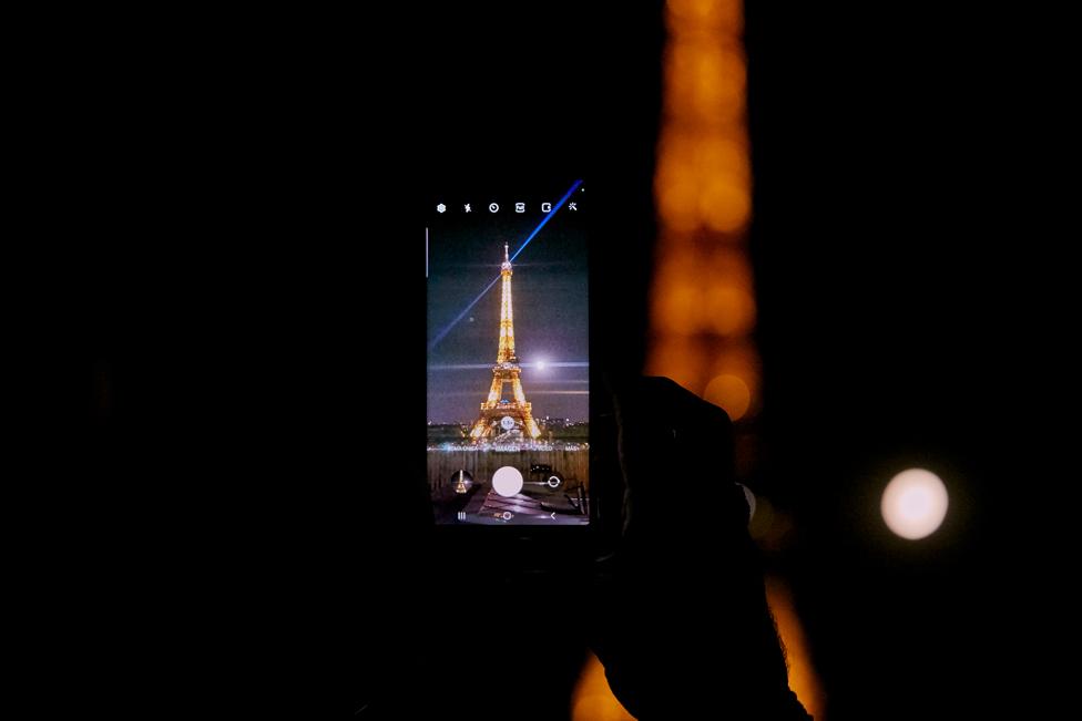 Full moon rises in the sky next to the Eiffel Tower in Paris, France