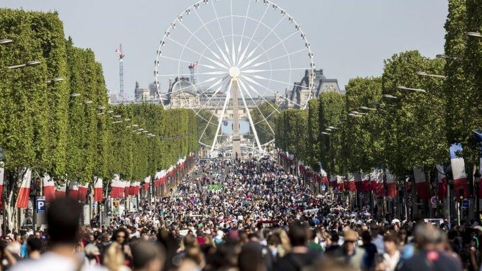 People walk on the Champs Elysees in Paris (08 May 2016)