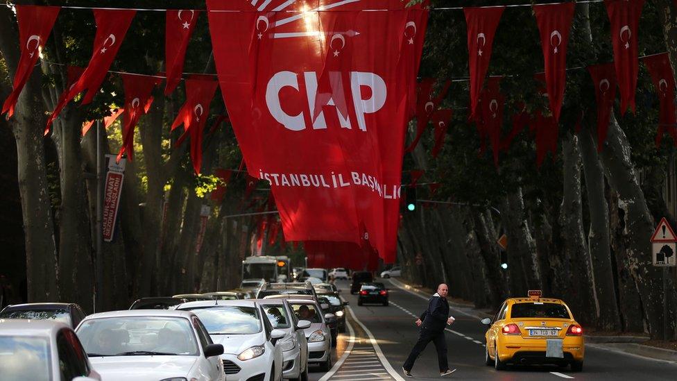 A man crosses a street under flags of Turkey's main opposition Republican People"s Party (CHP), in Istanbul, Saturday 31 October 2015