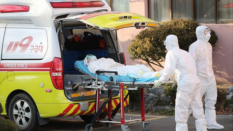 Medical workers wearing protective gear transfer a suspected coronavirus patient to another hospital from Daenam Hospital in Cheongdo. 21 Feb 2020