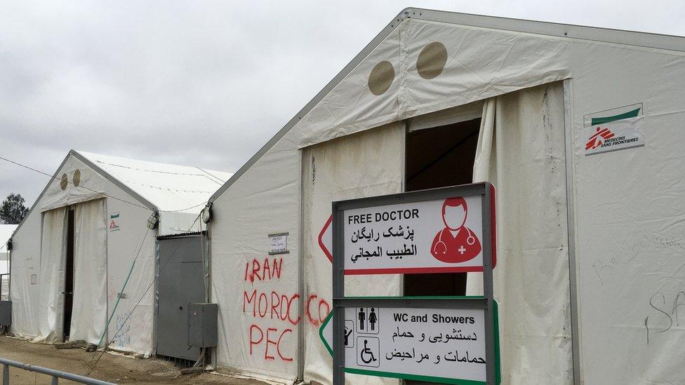 An aid camp in Greece. A sign reads "Free doctor"