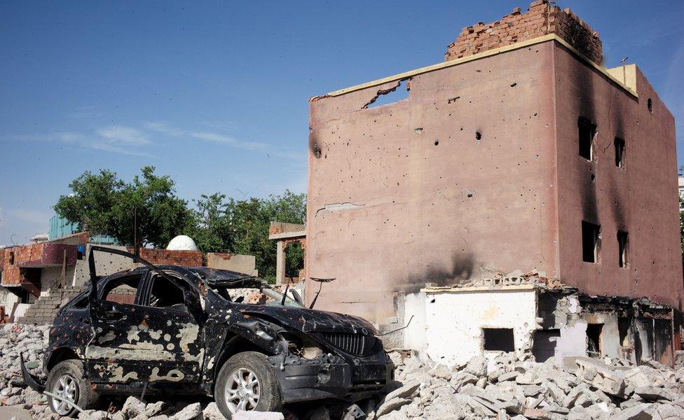 Badly damaged car and building in Cizre, Turkey - May 2016