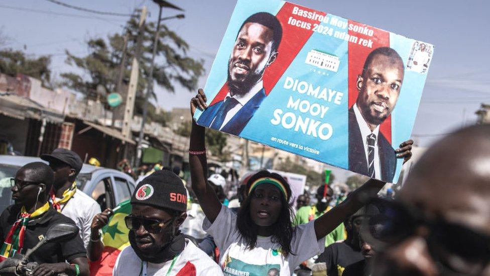 Supporters for the coalition of anti-establishment candidates holds up a poster with presidential candidate Bassirou Diomaye Faye and opposition leader Ousmane Sonko as they march during a campaign rally in Dakar, Senegal - 10 March 2024