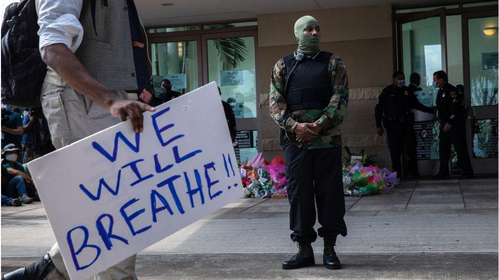 A member of the Black Panthers stands watch outside George Floyd's casket viewing in Houston