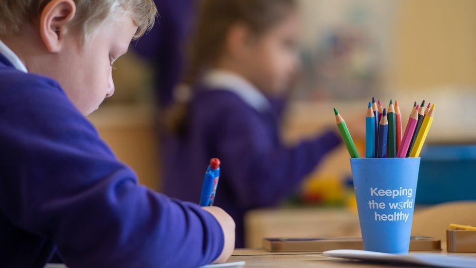 boy writes at desk