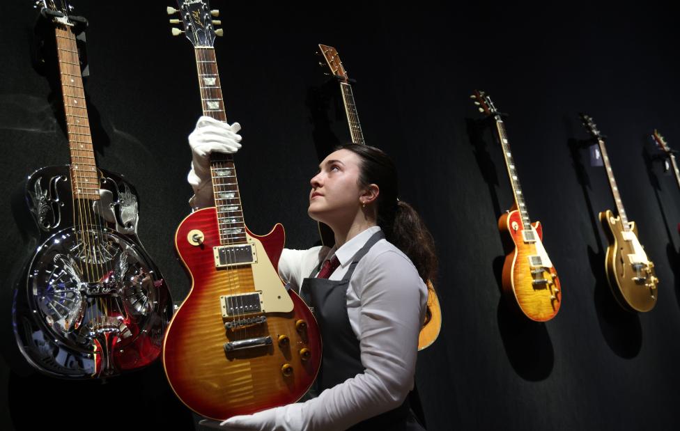 A Gibson Les Paul Standard electric guitar is held by a gallery worker during a photo-call for the Mark Knopfler Guitar Collection at Christie's Auction House in London, Britain, 18 January 2024.