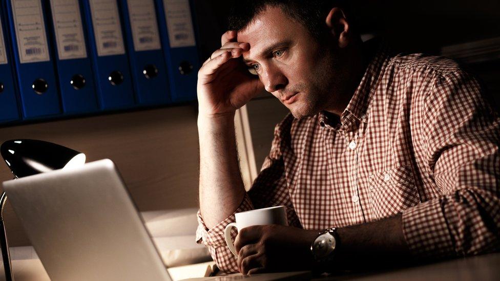 man working late on his computer