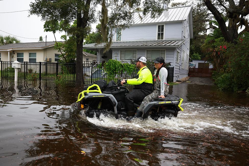 People ride an ATV through the flooded streets caused by Hurricane Idalia passing offshore on August 30, 2023 in Tarpon Springs, Florida