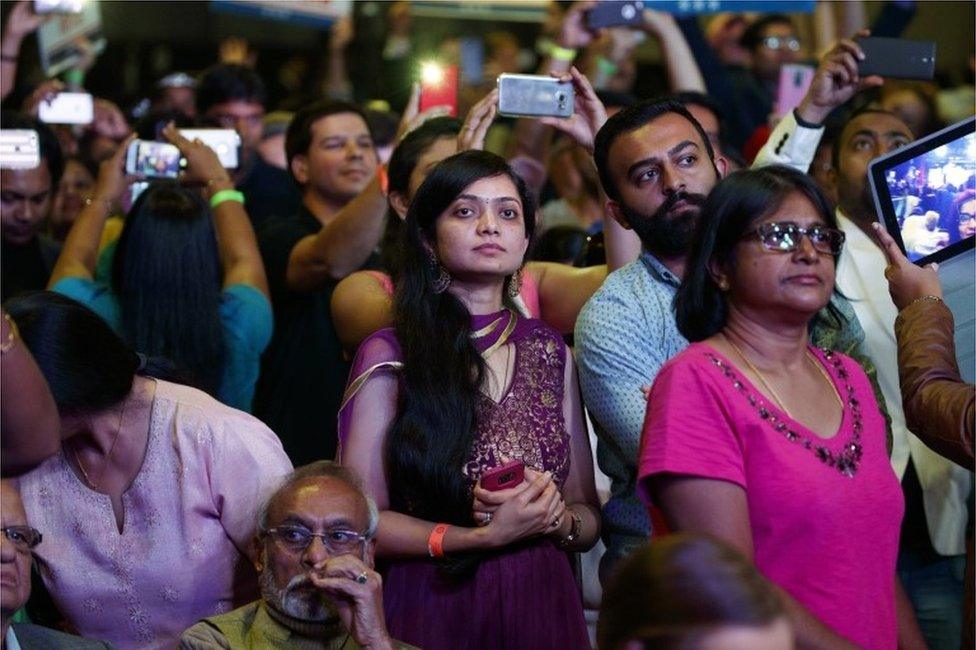 People look on as Republican presidential candidate Donald Trump speaks to the Republican Hindu Coalition, Saturday, Oct. 15, 2016, in Edison, N.J.