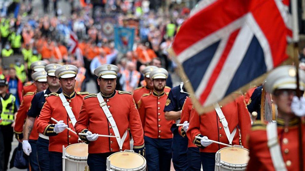 Members of the Orange Order and their supporters march through the city