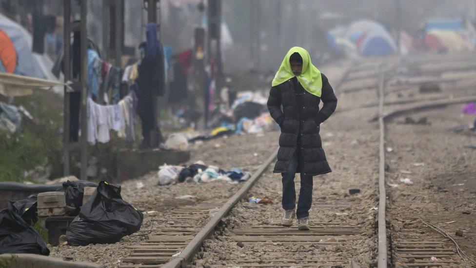 A migrant man walks on railway tracks in Greece