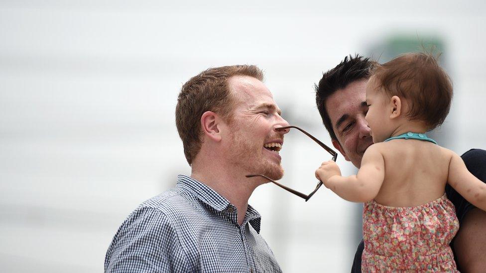 Gordon Lake (centre) and Spaniard Manuel Valero (right) play with their daughter Carmen after a court hearing at The Central Juvenile and Family Court in Bangkok (30 March 2016)