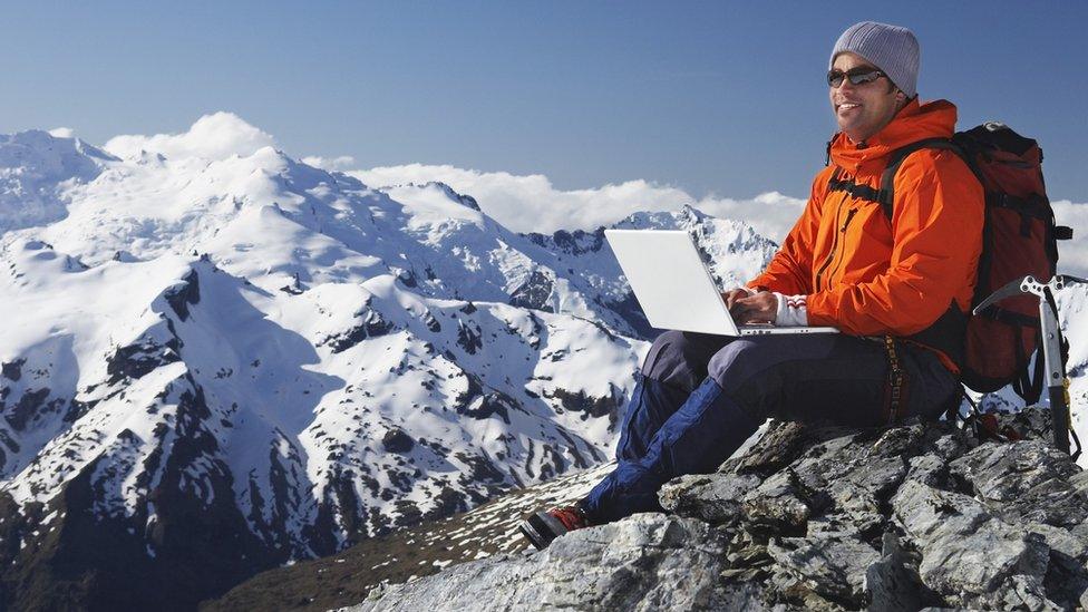 man up mountain with laptop