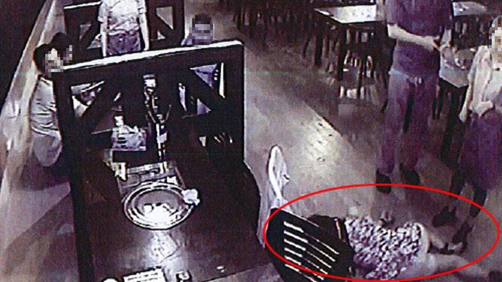 CCTV image shows customers and staff looking at the intoxicated woman on the floor