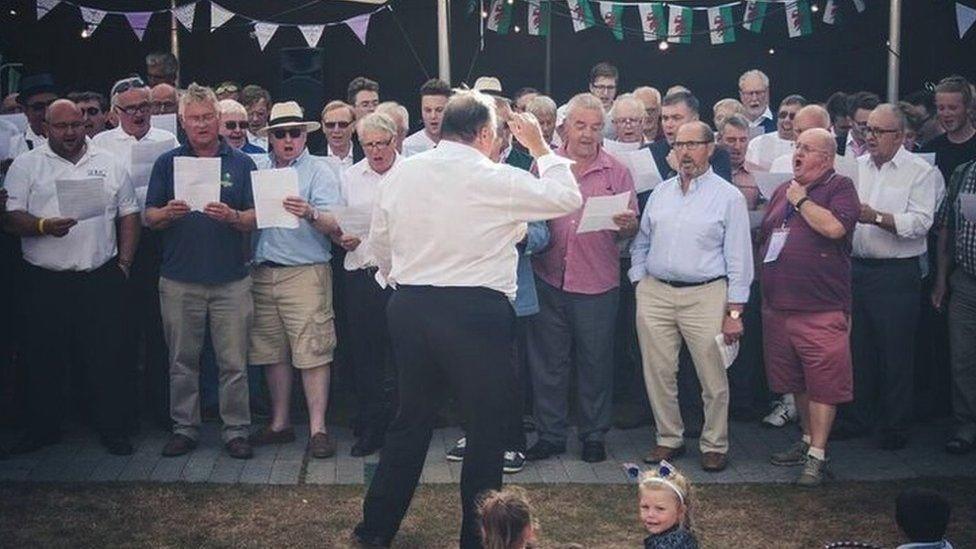 John Eifion, arweinydd Côr Y Brythoniaid, yn arwain y tenoriaid mewn ymarfer ar gyfer Eisteddfod Llangollen 2017