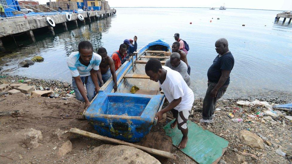 People pulling a boat out of water