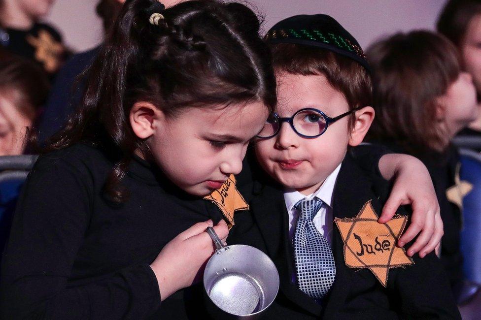 Children take part in a memorial ceremony for Holocaust victims