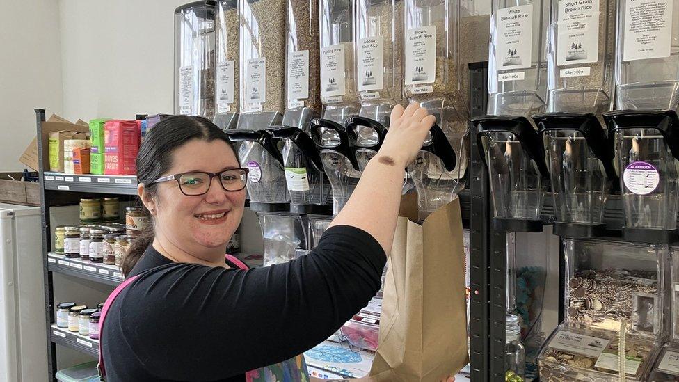 Kirsty Scott pouring rice out of a dispenser into a brown paper bag