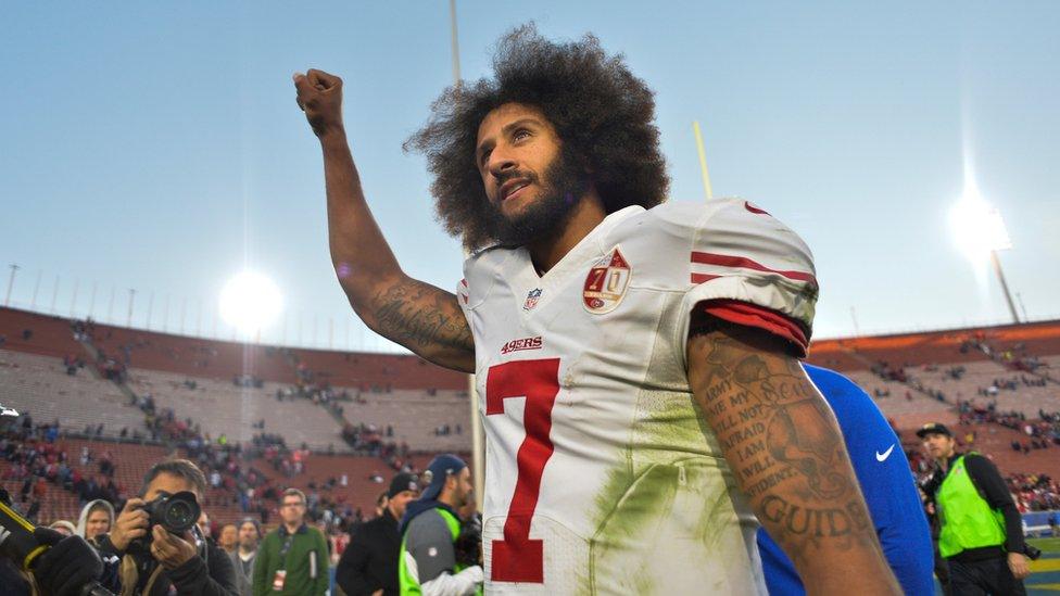 Colin Kaepernick pumps his fist as he acknowledges the cheers at Los Angeles Memorial Coliseum in Los Angeles