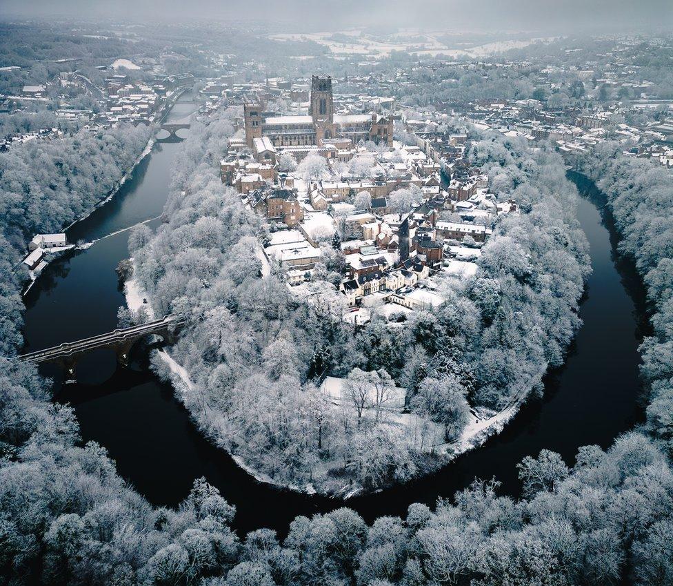 Aerial view of the horseshoe shaped river in Durham circling around Durham Cathedral in the snow