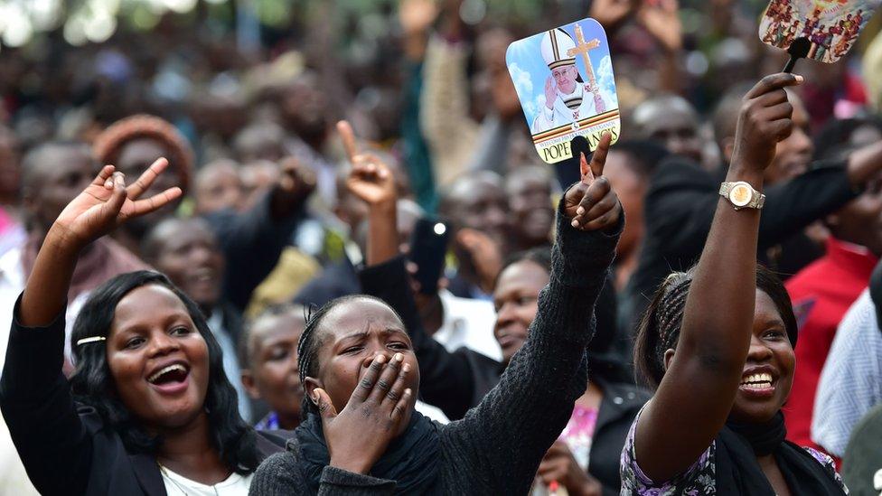 People react as they wait for the arrival of Pope Francis for an open mass in Kampala, Uganda, on Saturday