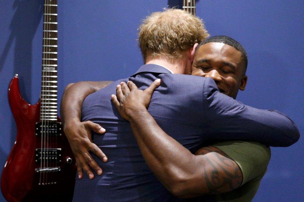 Prince Harry embracing US Marine Sgt Roderic Liggens