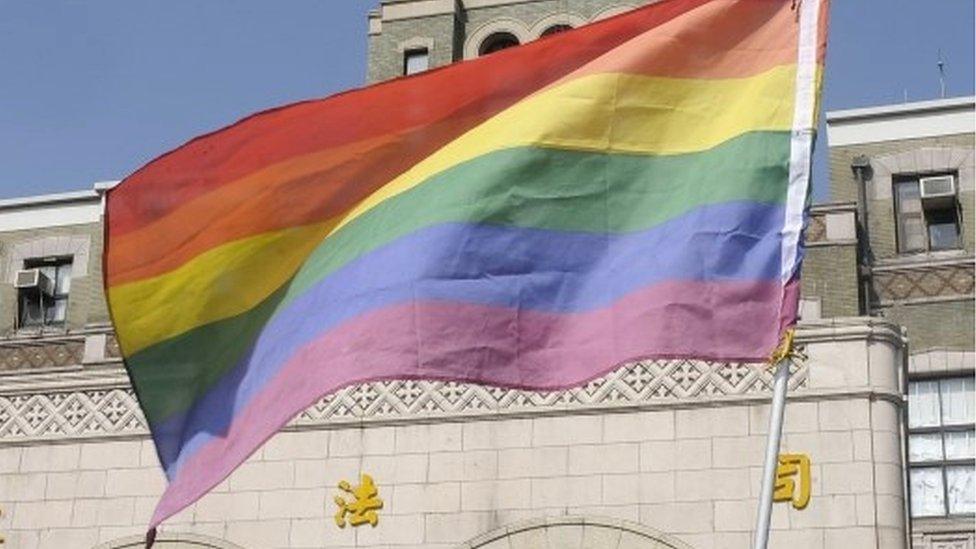 A supporter of same-sex marriage waves a flag outside the Judicial Yuan in Taipei on 24 March 2017.