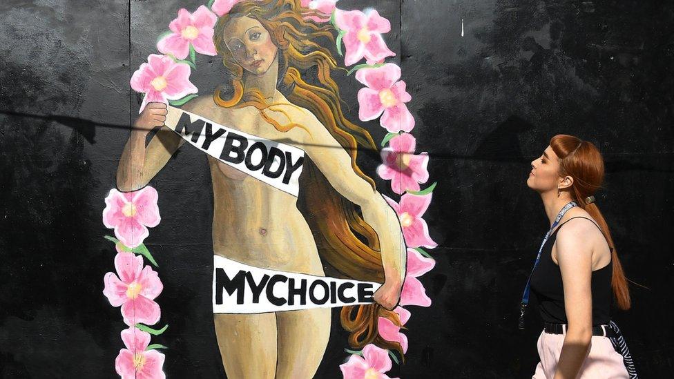 A woman walks in front of a pro-choice mural relating to the laws regarding abortion in Dublin