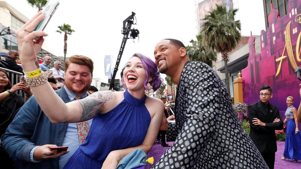 Will-Smith-poses-for-a-photo-with-a-fan.