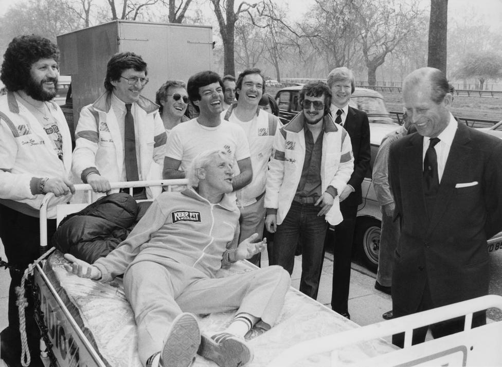 Jimmy Savile talking to the Duke of Edinburgh in 1981 while other Radio 1 djs look on