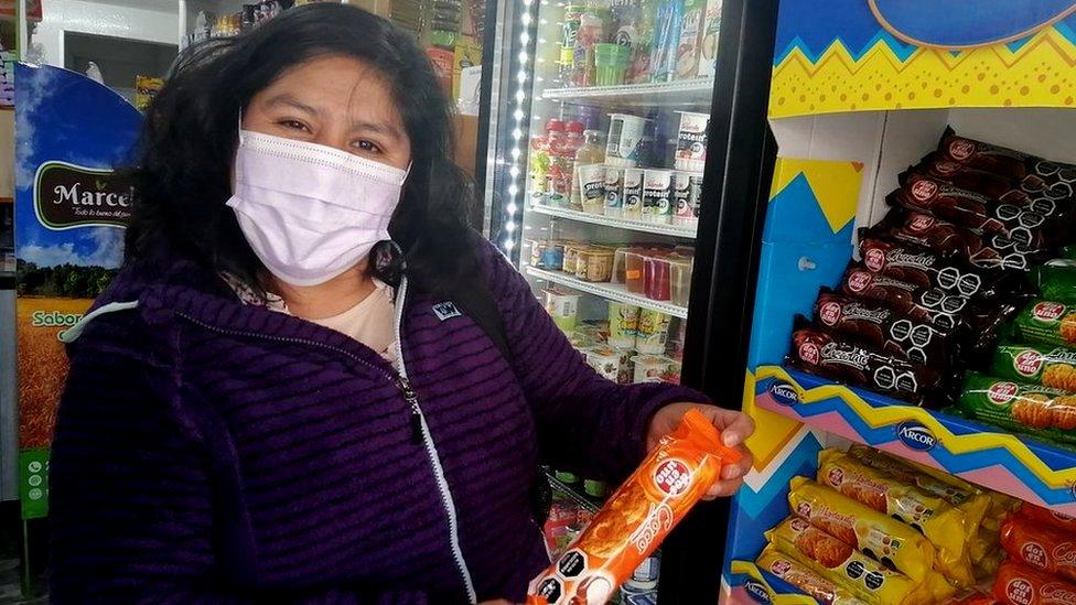 Rosa Cayso Phocco holds a packet of biscuits with a warning label in Chile