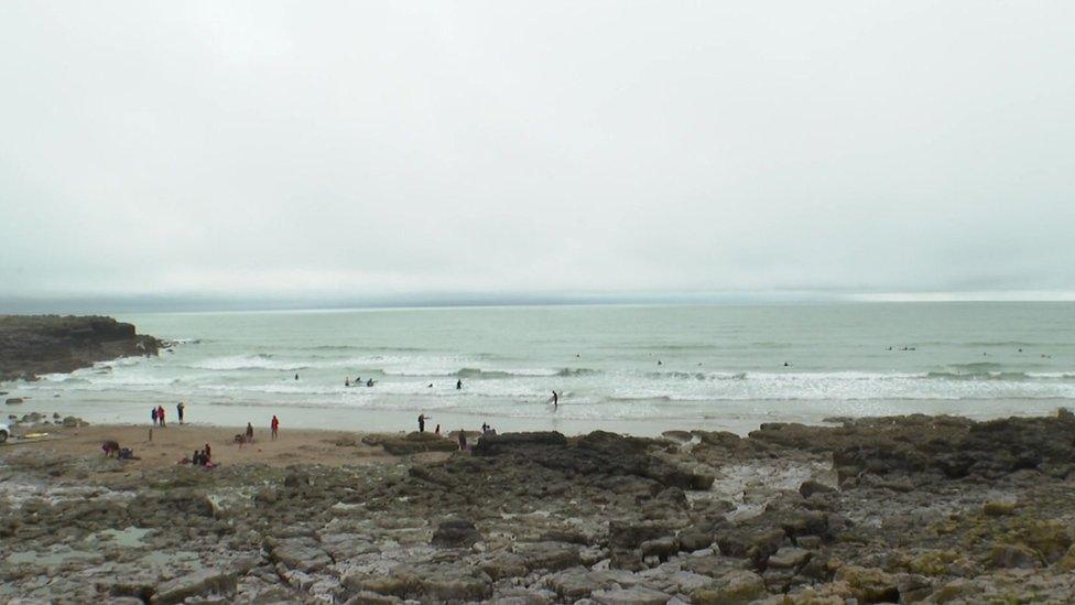 beach with swimmers and surfers