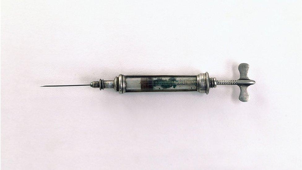 A Pravaz type syringe, made of glass and silver with a screw instead of a plunger