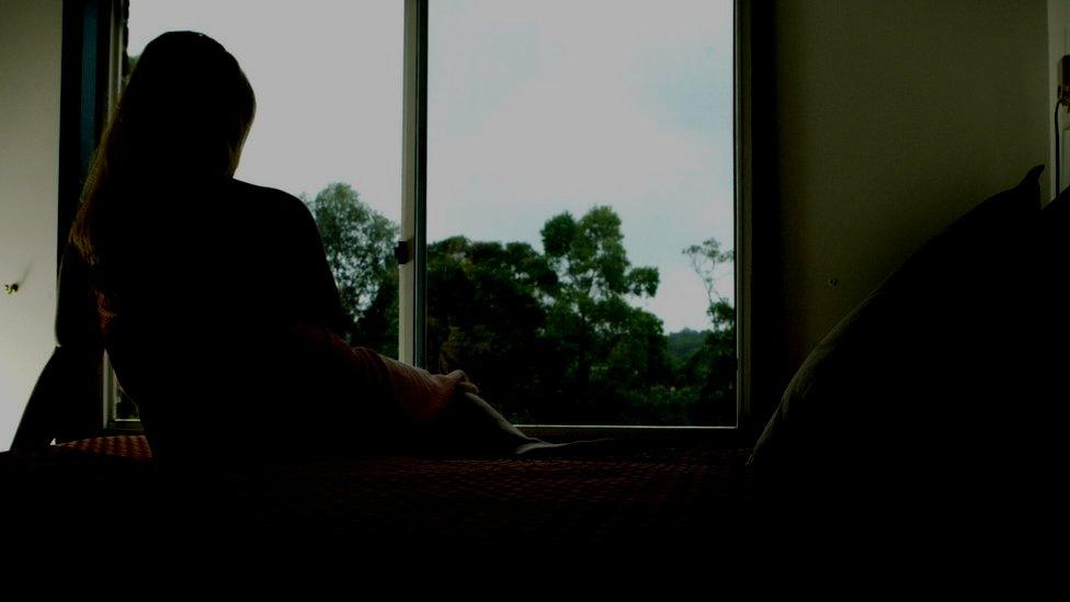 Woman sitting by window