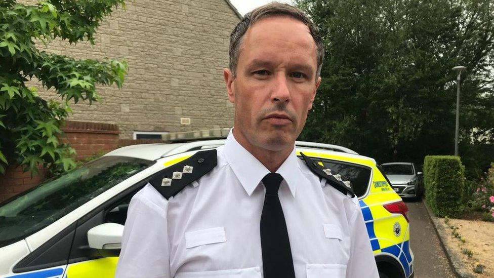 Chief inspector Adam O’Loughlin standing in front of a police car