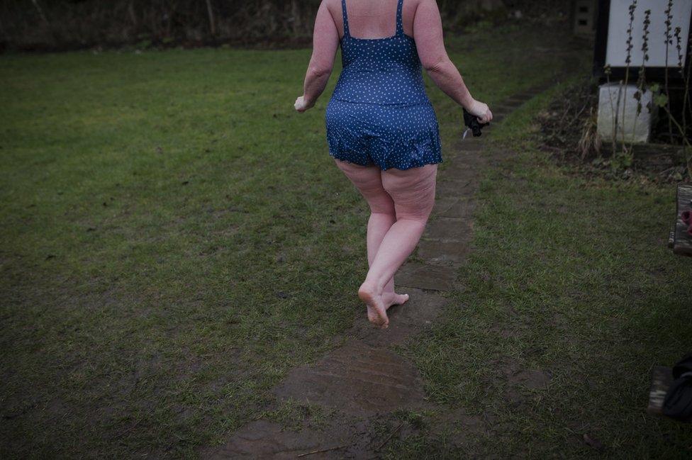 A woman walks on grass