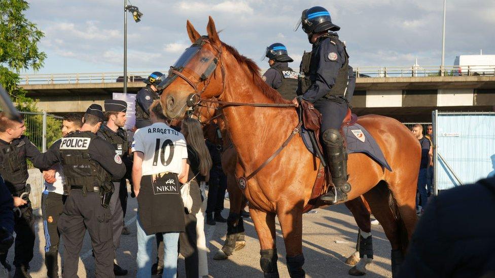 Police on horseback next to Real Madrid fans.