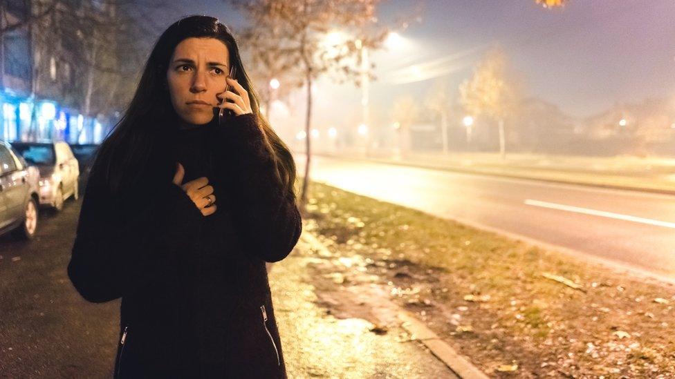 Woman on the phone, walking alone at night