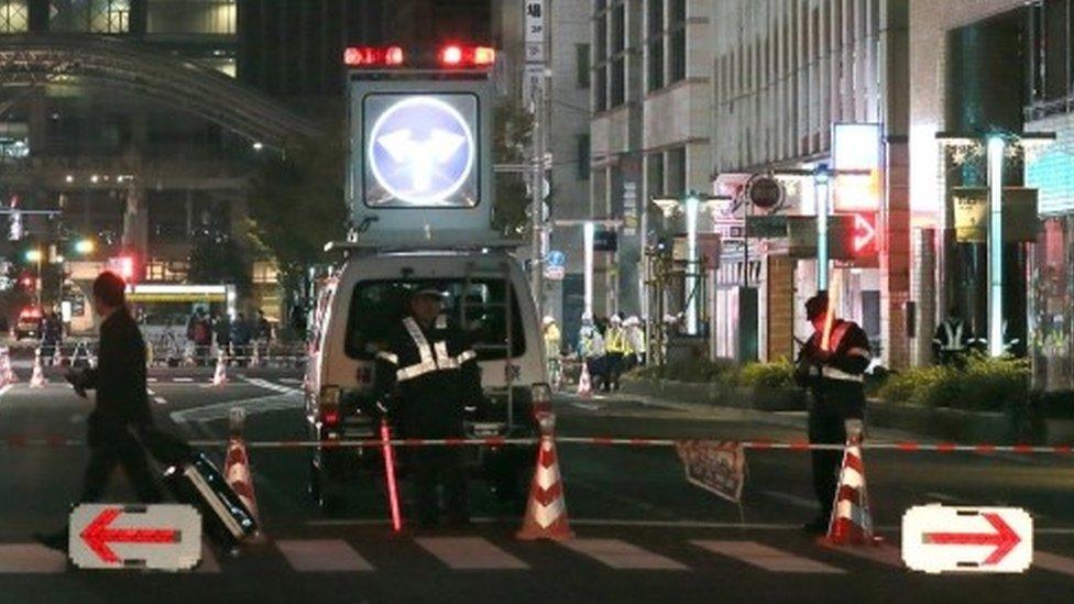 Policemen stand guard on a street in Fukuoka after it was again temporarily closed over the weekend (26 November 2016)