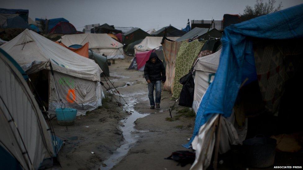 A man walking between tents