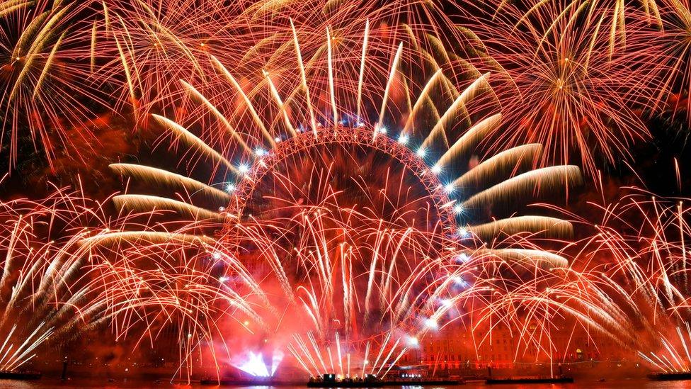 Fireworks explode over the iconic London Eye marking the beginning of the New Year in central London