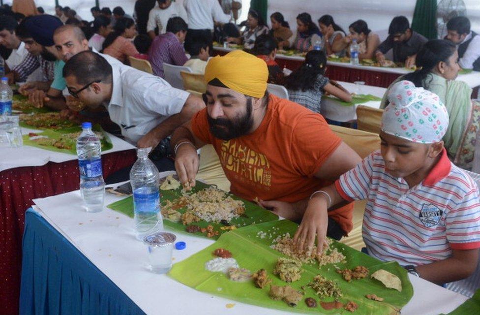 Indian diners eat a special mass lunch of 27 vegetables curries known as 'Onam Sadya' in New Delhi on September 17, 2013