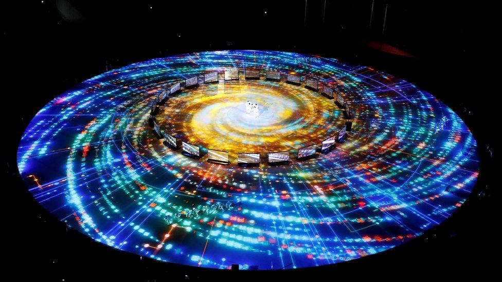 A light show is projected on the floor to look like the Milky Way galaxy